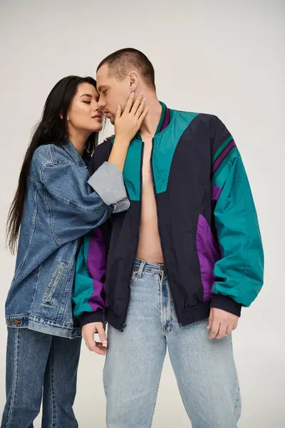 Una joven pareja se abraza alegremente en trajes de moda, celebrando el amor y la conexión juntos. — Stock Photo