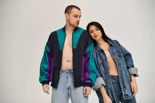 A beautiful young couple in trendy outfits expresses their love in a chic studio setting. — Stock Photo