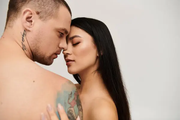 A seductive embrace captures the passion of a couple celebrating love in a studio setting. — Stock Photo
