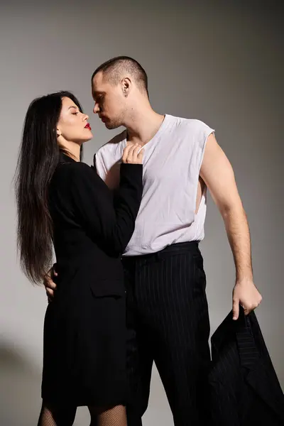 Young couple dressed in fashionable outfits shares a romantic moment in the studio. — Stock Photo