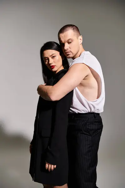 A beautiful young couple embraces warmly in stylish outfits, capturing the spirit of romance. — Stock Photo