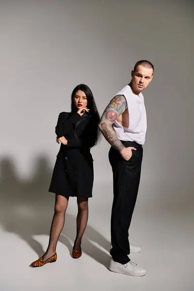 Young couple showcases their fashion sense in a trendy studio setting — Stock Photo
