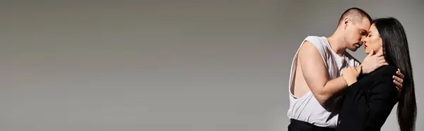 A beautiful young couple shares an intimate moment in a studio setting, embracing love, banner — Stock Photo