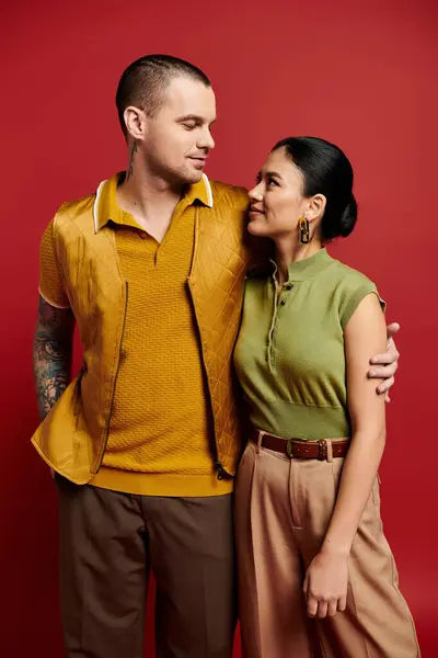 A young couple showcases their fashion sense, sharing a loving glance in a vibrant studio. — Stock Photo