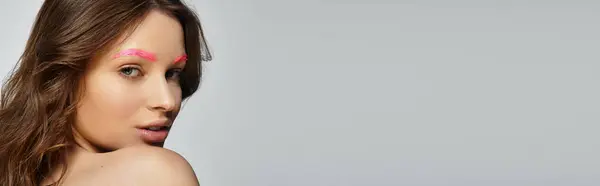 Young woman highlights her pink eyebrows and unique style against a grey background, banner — Stock Photo