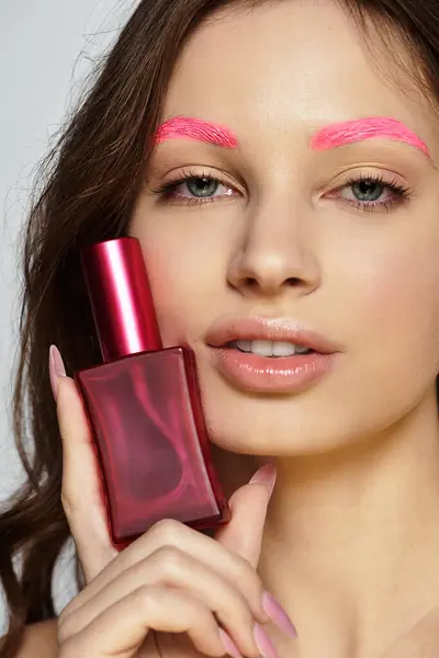A young woman showcases her striking beauty and bold style with pink eyebrows in a studio. — Stock Photo