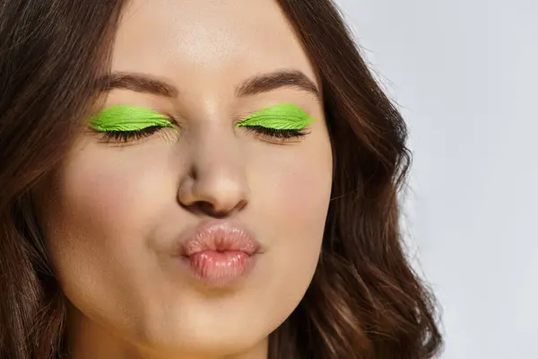 Vibrant green eyeshadow highlights her beauty, while playful expression captures youthful energy. — Stock Photo