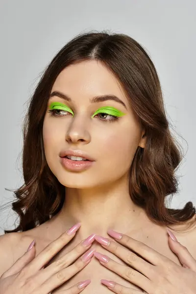 Une jeune femme affiche sa beauté saisissante avec un fard à paupières vert audacieux, captivant et chic. — Photo de stock