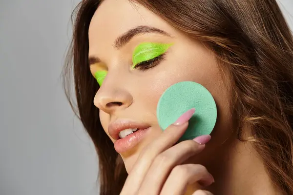 Attractive young woman showcases her bold makeup style with stunning green eyeshadows. — Stock Photo
