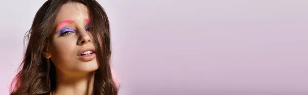 Молодая женщина подчеркивает свою поразительную красоту и смелый стиль макияжа в студии настройки, баннер — стоковое фото