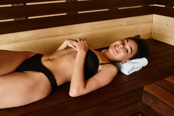 A young African American woman lies back in a spa, enjoying a peaceful moment of relaxation. — Stock Photo