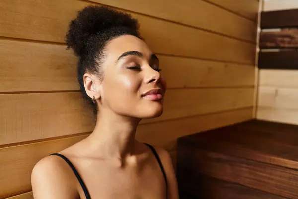 A young African American woman enjoys a peaceful moment in a spa, embracing complete relaxation. — Stock Photo