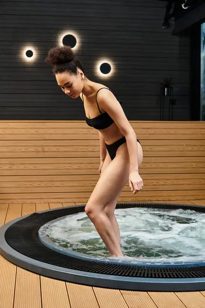 Beautiful young woman steps into a soothing spa hot tub, embracing relaxation and tranquility. — Stock Photo