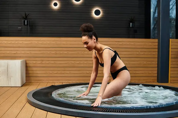 A young African American woman relaxes in a soothing spa whirlpool, finding tranquility. — Stock Photo