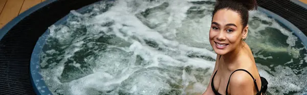 Young woman relaxes in a bubbling spa whirlpool, embracing serenity and blissful calmness. — Stock Photo