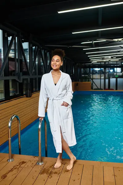 Uma jovem afro-americana está na piscina do spa, sentindo-se relaxada e despreocupada. — Fotografia de Stock