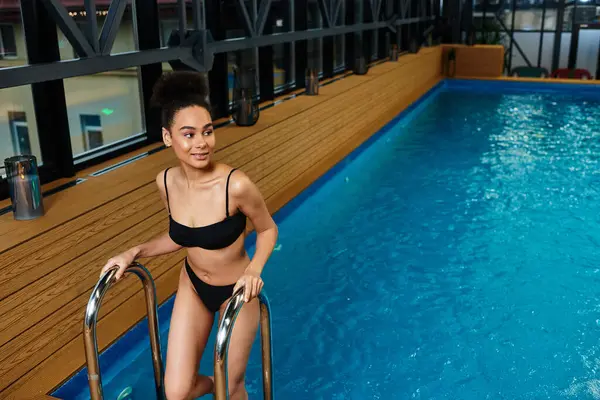 A young African American woman relaxes at a modern spa, enjoying the soothing ambiance and water. — Stock Photo