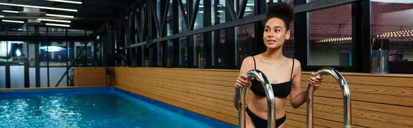 A young african american woman enjoys a moment of relaxation by the tranquil spa poolside. — Stock Photo