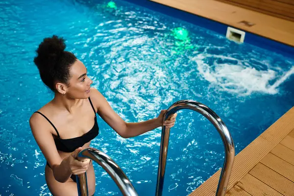 Relaxation takes center stage as a young woman steps into a serene spa pool, embracing peace. — Stock Photo