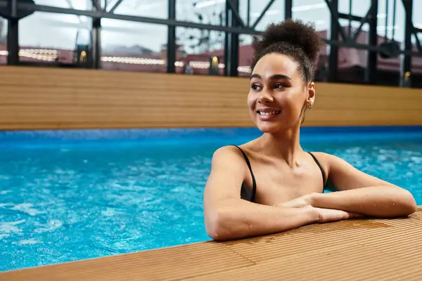 Young african american woman enjoying peaceful moments by the pool, radiating joy and tranquility. — Stock Photo