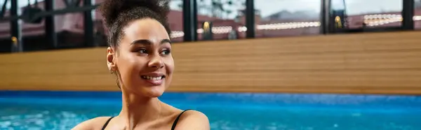 A beautiful young woman embraces relaxation in a serene spa setting, unwinding by the pool. — Stock Photo
