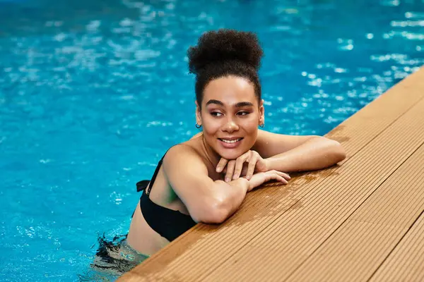 A beautiful young African American woman unwinds at a spa, enjoying peaceful moments in the water. — Stock Photo