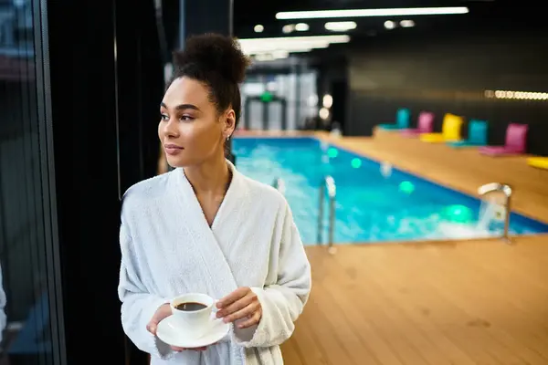 A young woman relaxes in a peaceful spa setting, sipping coffee and enjoying the calming atmosphere. — Stock Photo