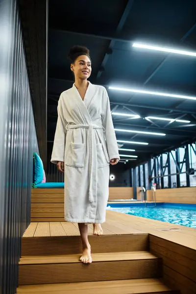 A beautiful young woman walks barefoot towards a serene pool area, embodying relaxation and joy. — Stock Photo