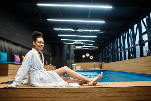 A young woman enjoys a serene moment by the pool, embodying relaxation and self care. — Stock Photo