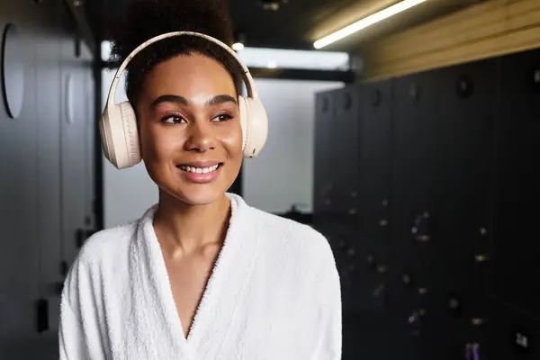 A young african american woman enjoys the tranquility of a spa while wearing headphones. — Stock Photo