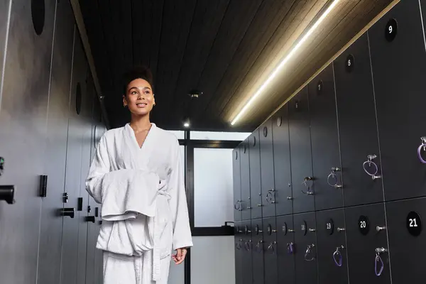 A beautiful young woman walks through a modern spa area, radiating joy and tranquility. — Stock Photo