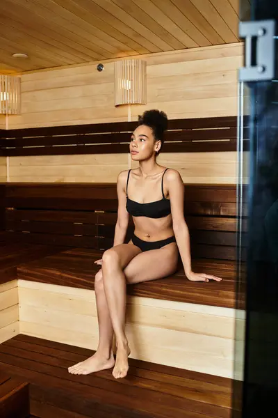 Une jeune femme afro-américaine embrasse la tranquillité dans un spa, rayonnant de beauté et de détente. — Photo de stock