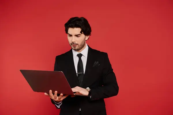 Handsome young man in formal attire engages with his laptop, immersed in his work or study. — Stock Photo