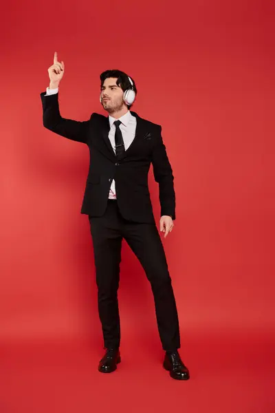 In a vibrant scene, a stylish young man radiates joy and confidence while enjoying the music. — Stock Photo