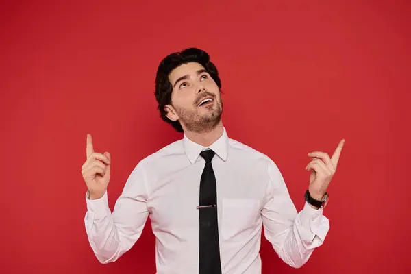 Brunette man wearing a white shirt and tie looks up with excitement, smiling in a lively setting. — Stock Photo