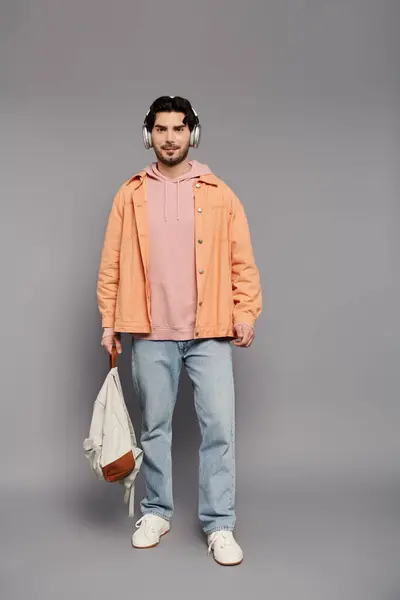 Ein selbstbewusster junger Mann steht groß in einem lässigen, schicken Outfit und präsentiert sein stilvolles Flair. — Stockfoto