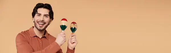 Un giovane gioca gioiosamente maracas, irradiando energia in uno spazio colorato. — Foto stock