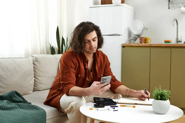 In a stylish apartment, a young man with diabetes engages in his daily routine, managing health. — Stock Photo