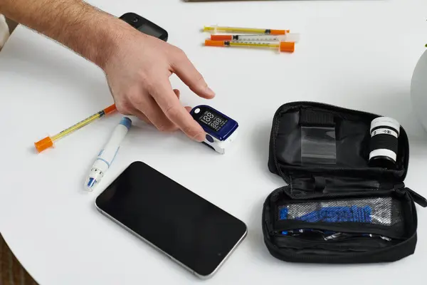 Young man checks blood sugar levels while maintaining his diabetes routine at home. — Stock Photo