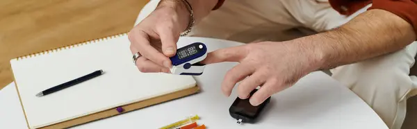 Young man monitors blood sugar and prepares insulin in his stylish living space, showing resilience, banner — Stock Photo