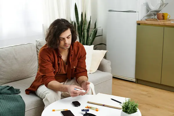 Un joven navega por la vida cotidiana en un apartamento moderno mientras maneja la diabetes. - foto de stock