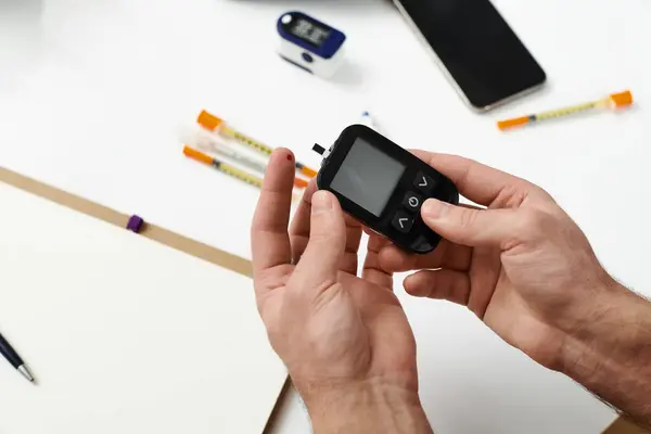 A young man with diabetes checks his blood sugar while preparing for daily tasks at home. — Stock Photo