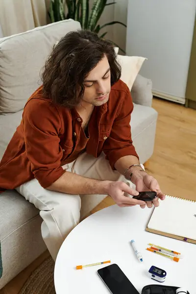 Young man practices self-care at home while monitoring his diabetes daily routine. — Stock Photo