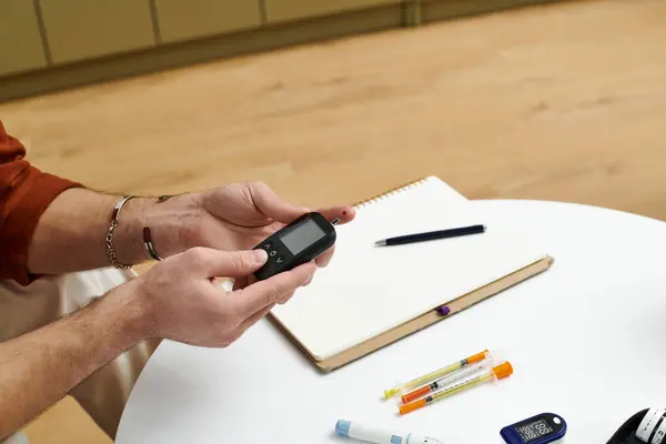 A young man checks his blood sugar levels while preparing insulin in his stylish home. — Stock Photo