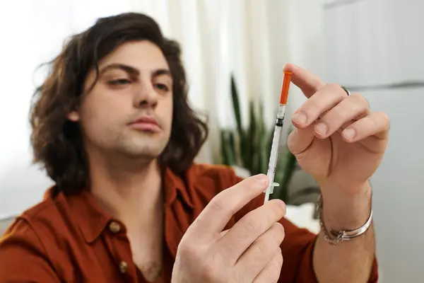 Caucasian man with long hair carefully prepares insulin while maintaining his life with diabetes. — Stock Photo