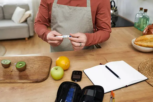 This young man leads a healthy life, checking his blood sugar and enjoying fresh fruit. — Stock Photo