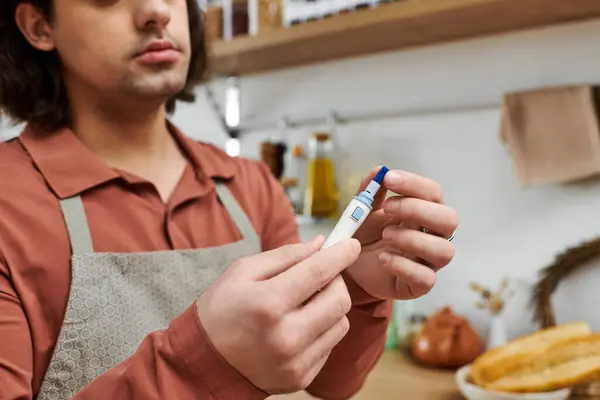 Young man with diabetes carefully checks his blood sugar levels at home, demonstrating his routine. — Stock Photo