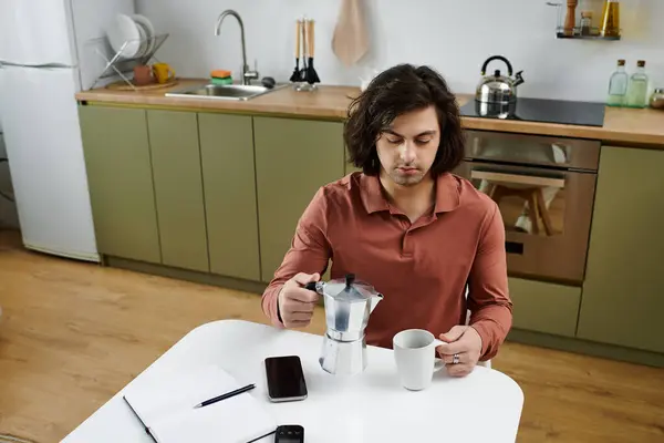 Young man prepares his morning coffee while managing diabetes in his stylish kitchen. — Stock Photo