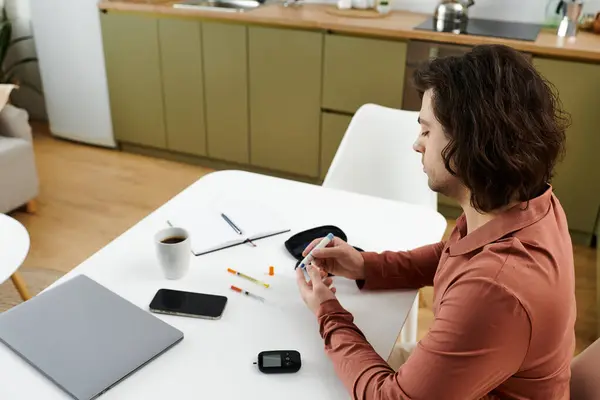 A young man checks his blood sugar and prepares insulin in a stylish, comfortable home setting. — Stock Photo