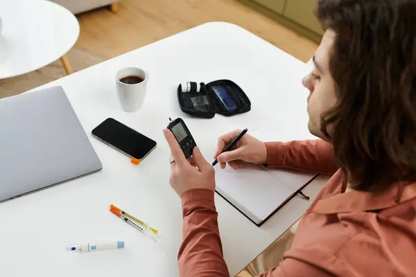 Caucasian man monitors blood sugar levels and documents health in modern apartment setting. — Stock Photo